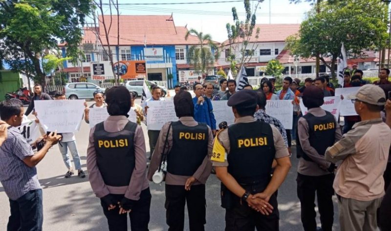 Puluhan masyarakat dari lima kabupaten saat menyampaikan orasinya di depan Kantor Gubernur Kalteng, dikawal aparat kepolisian Jumat (28/6/2019). 