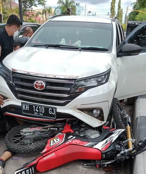 Korban saat tergeletak dibawah mobil dan sepeda motor ketika terlindas ban depan mobil Senin (22/6). 
