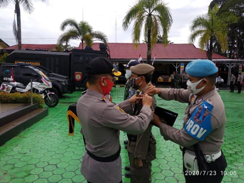 Kapolres Kobar AKBP E Dharma B Ginting saat menyematkan tanda pita kepada petugas Kamis (23/7). 