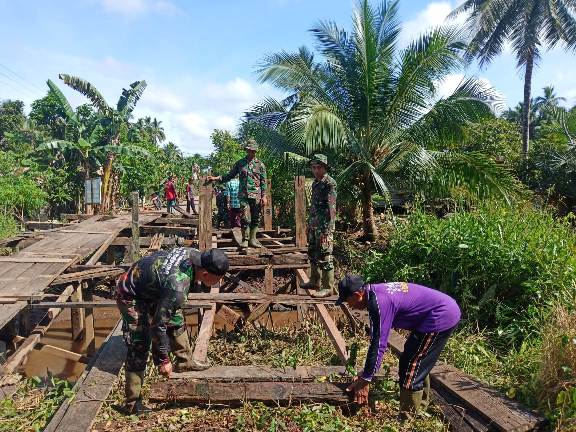 Anggota TNI Kodim 1015 Sampit saat gotong royong memperbaiki jembatan di TMMD Desa Bapinang Hilir Jumat (25/9). 