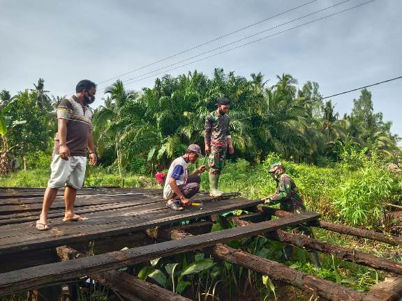 Warga berpartisipasi memperbaikan jembatan dan mushalla dalam kegiatan TMMD Reguler ke-109 di Kecamatan Pulau Hanaut.