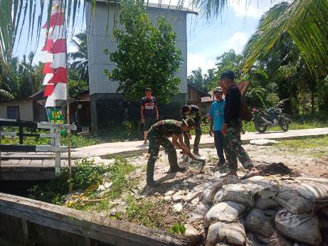 Anggota TNI saat gotong royong membangun desa. 