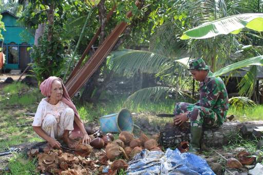 Anggota TNI saat membantu petani kopra mengupa kelapa Kamis (8/10). 