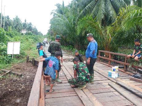 Anggota TNI dan warga saat mengerjakan jembatan yang hanya menyisakan sedikit lagi rampung Kamis (15/10). 