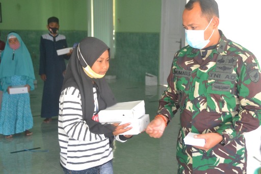 Anggota TNI saat berbagi dengan anak yatim. 