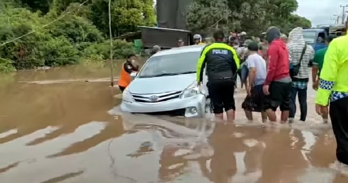 Sebuah mobil Avanza saat memaksa nekat untuk melintasi ruas jalan yang direndam banjir, Sabtu (13/11). 