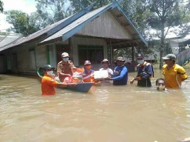 EVAKUASI - Tim reaksi cepat BPBD Kabupaten Lamandau saat membantu warga menyeberang melewati banjir. (Adzikkra El Varsha)