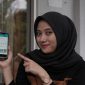 Salah seorang wanita sedang memperlihatkan aplikasi SwaCam PLN di ponsel. Aplikasi ini untuk memudahkan masyarakat memantau penggunaan listrik. (Foto : PLN)